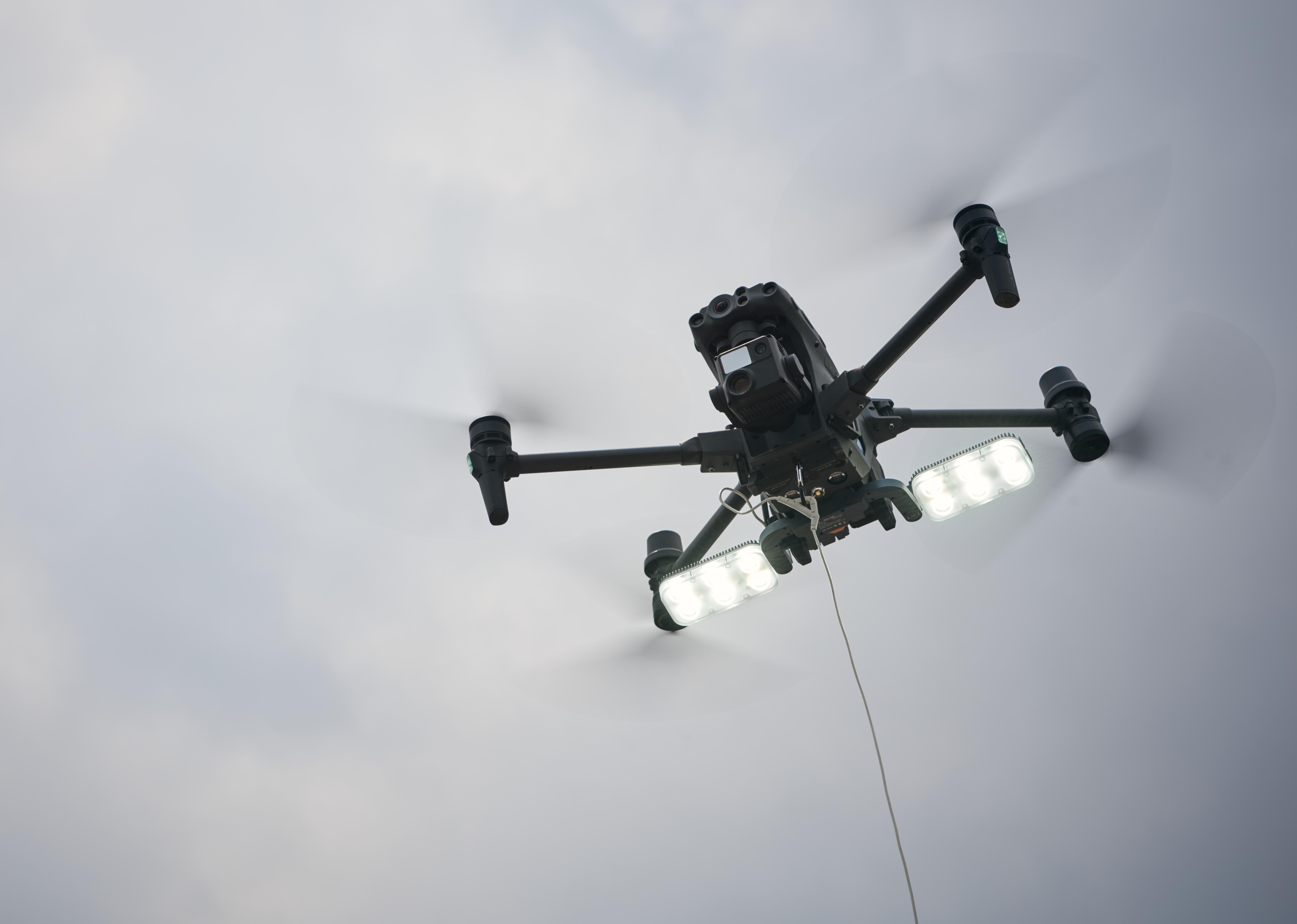 Drones with searchlights and TK3 tethers,realises long-time stationing in the air.